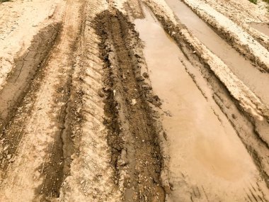 Kirli, pis, çamurlu, çamurlu, çamurlu, çatlak ve tekdüze çamurlu toprak bir yol. Off-road. Arkaplan