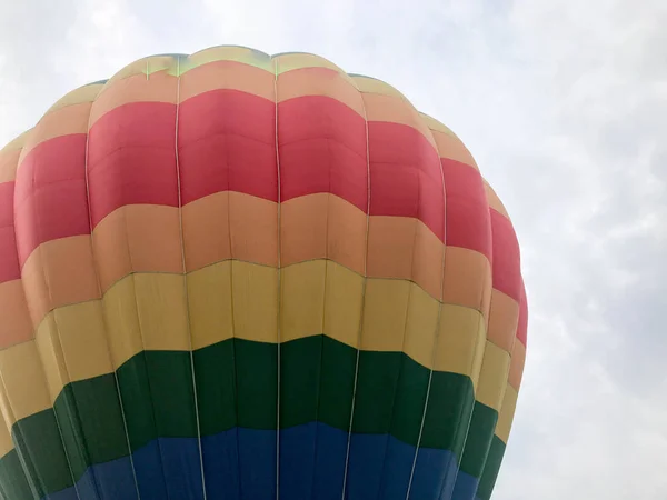 Wielobarwne rundy tęczowy jasny kolorowy pasiasty paski latający balon z koszem przeciwko niebo wieczorem — Zdjęcie stockowe