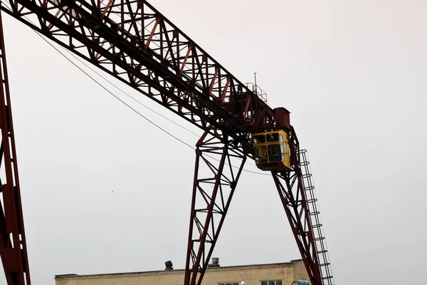 工业铁大型金属门式起重机, 吊钩安装在支架上, 用于搬运重型货物, 沿导轨在工厂移动。桥式起重机 — 图库照片