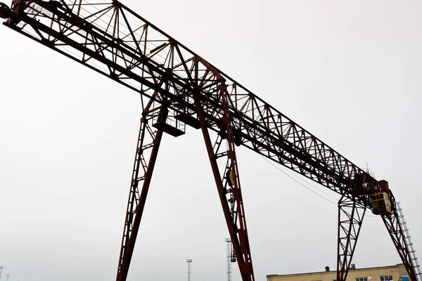 Industrielles Eisen großen Metallportalkran mit einem Haken auf den Stützen für das Heben und Tragen von schwerer Fracht montiert, bewegt sich entlang der Schienen in der Fabrik. Der Kran ist vom Brückentyp — Stockfoto