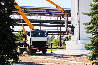 Özel bir teknik sütunlarda onarın. Vinç işçilerin büyük beyaz sütun onarmak. Resim ile kozmetik onarım. 