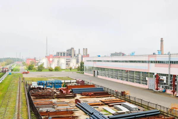 Endüstriyel manzara. Panoramik teknolojik borular. Paslı boruları, mavi yakut, üretim iletişim. Üretim binalar tamir. Puslu bir gökyüzü arka planı