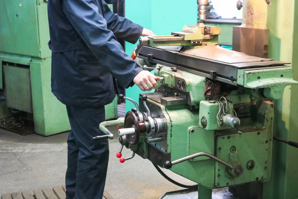 Um trabalhador do sexo masculino trabalha em um torno de serralheiro de ferro de metal maior, equipamentos para reparos, trabalho de metal em uma oficina em uma planta metalúrgica em uma produção de reparo — Fotografia de Stock