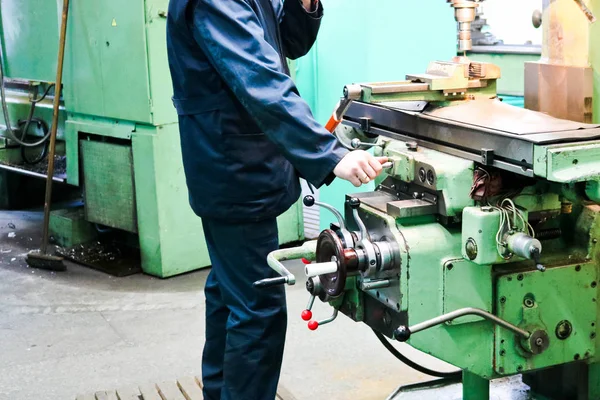 Um trabalhador do sexo masculino trabalha em um torno de serralheiro de ferro de metal maior, equipamentos para reparos, trabalho de metal em uma oficina em uma planta metalúrgica em uma produção de reparo — Fotografia de Stock