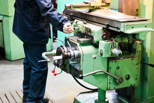 Um trabalhador do sexo masculino trabalha em um torno de serralheiro de ferro de metal maior, equipamentos para reparos, trabalho de metal em uma oficina em uma planta metalúrgica em uma produção de reparo — Fotografia de Stock