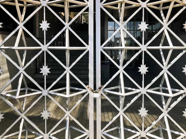 Portas de ferro, cerca de barra de metal congelada em uma forte corrente enferrujada de elos em uma grande fechadura do celeiro. O fundo — Fotografia de Stock