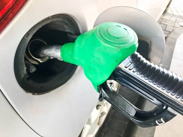 緑充填ピストルはガソリン スタンドで車のガソリン タンクに立ち往生。燃料、ガソリン、ディーゼル車を充填プロセス — ストック写真