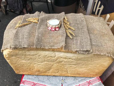 Bir büyük, büyük dikdörtgen somun beyaz ev yapımı, ev yapımı buğday ekmek bir kabuk ve tuz. Konuklar karşılamak için Rus geleneği. ekmek eller tarafından yapılan