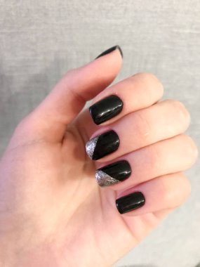 Güzel el ince parmaklı ve siyah manikür çivi üzerinde gümüş sparkles boyasıyla jel ile