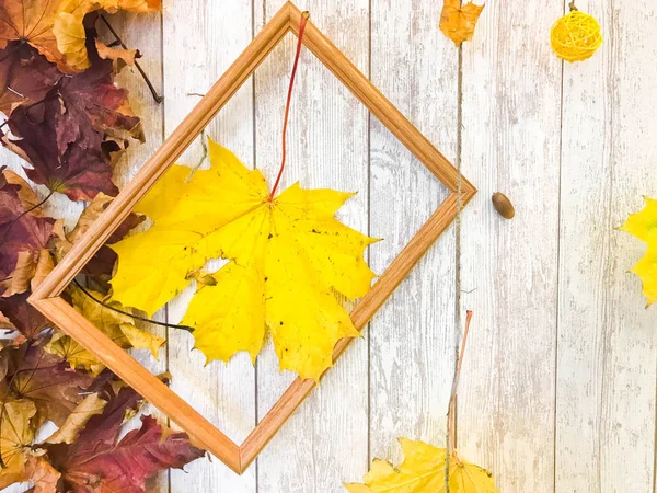 木制长方形镜框和黄色五颜六色的自然秋叶, 枫树在木板的背景下。背景。纹理 — 图库照片