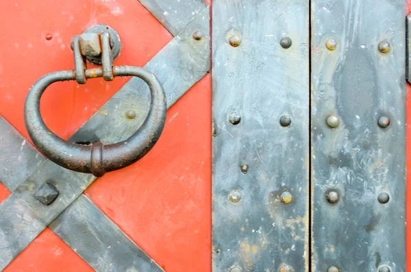 Texture d'une ancienne porte antique en fer rouge antique avec rivets et motifs de clous. Le contexte — Photo