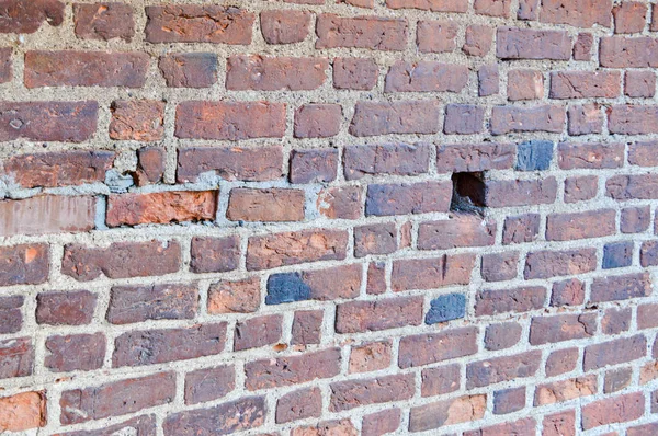 La texture de la vieille pierre antique médiévale robuste peeling mur rayé de brique lumineuse rouge orange rectangulaire avec des coutures et des fissures. Le contexte — Photo