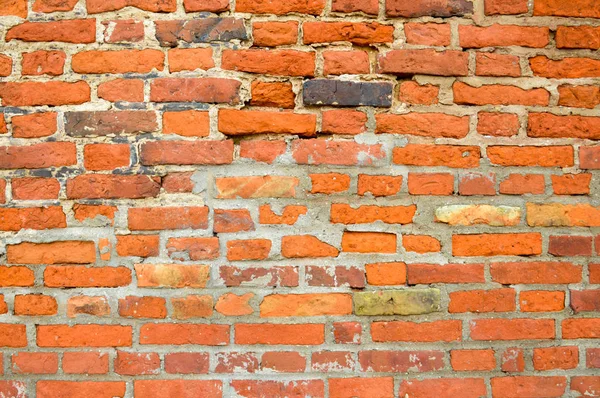 Die Textur der alten mittelalterlichen antiken stabilen Stein abblätternden zerkratzten Wand aus rechteckigen roten orange helle Ziegel mit Nähten und Rissen. der Hintergrund — Stockfoto