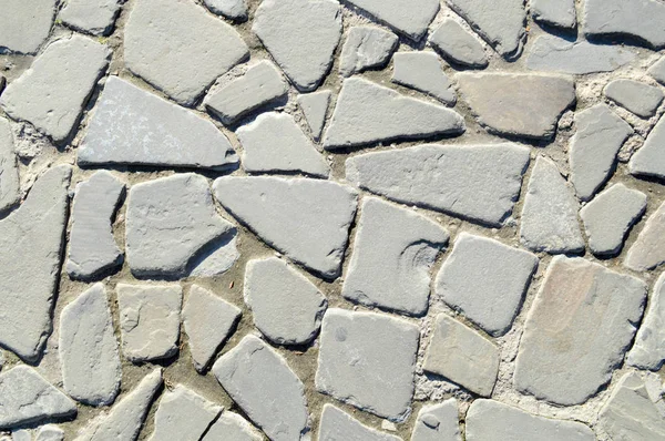 A textura da estrada de pedra, pavimento, paredes de grande cinza velho medieval redondo pedras fortes, pedras de paralelepípedos. O fundo — Fotografia de Stock