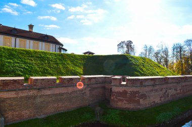 Büyük kırmızı toprak duvara güçlü koruyucu ise bir Hendek Savaşı mavi gökyüzüne karşı Avrupa'nın merkezinde eski, eski bir ortaçağ kalesi ile