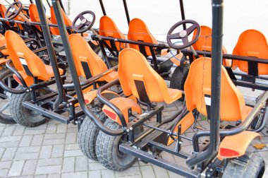 Birçok moda portakal spor dört tekerlekli bisikletler, döngüsü kartları için aile spor rekreasyon ve Turizm bir tekerlek ve pedallar ile sonbahar parkta Park