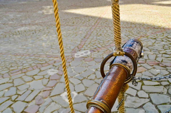 Antiguo spyglass pirata marrón antiguo atado con cuerdas contra un fondo de losas de pavimentación de piedra en el camino —  Fotos de Stock