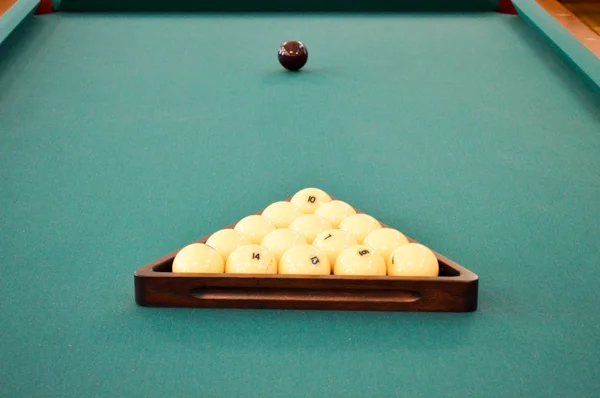 Green billiard sports table with billiards, a pool with a white and black ball and a triangle — Stock Photo, Image