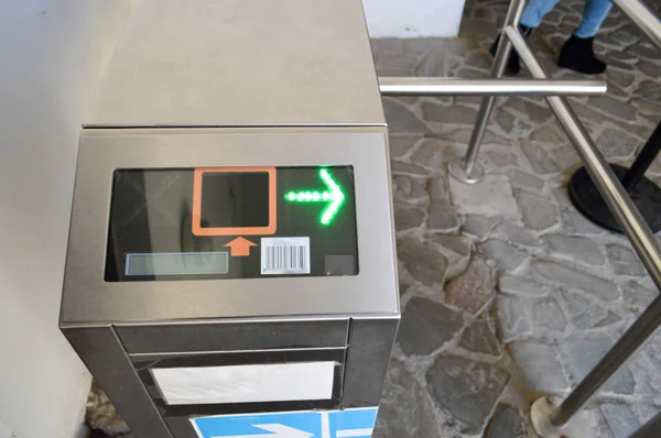 プラスチック カードの上の人々 を渡すため近代的な金属の自動改札機を通過します。緑の矢印と電気のチェックポイント — ストック写真