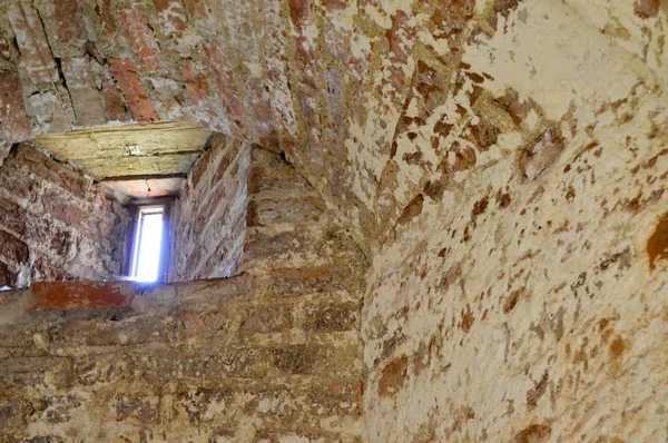 Una piccola finestra stretta su un vecchio, antico, incrinato muro di mattoni squallido pietra di mattoni rossi nel seminterrato. Lo sfondo — Foto Stock