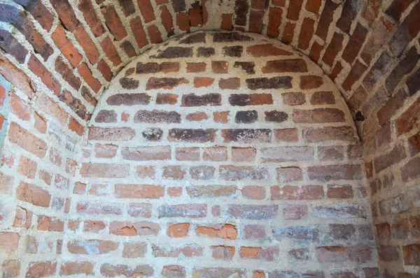 Une petite cavité étroite, une niche avec une arche sur un vieux mur de briques rouges épaisses en pierre dans un vieux château. Le contexte — Photo