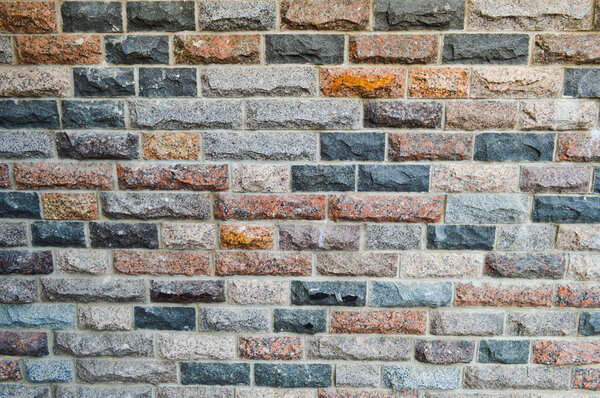 Texture of beautiful multi-colored rectangular bricks, tiles from natural marble and granite chips with seams. The background