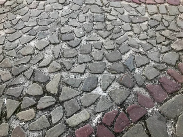 La texture de la route en pierre, la chaussée, les murs de grandes pierres rondes médiévales rondes grises, pavés. Le contexte — Photo