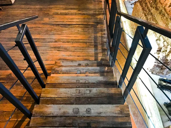 Una gran escalera marrón de madera que baja con escaleras y barandillas. El trasfondo — Foto de Stock