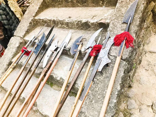 As antigas armas antigas medievais frias, machados, alabardas, facas, espadas com puxadores de madeira lambem nos degraus de pedra do castelo — Fotografia de Stock