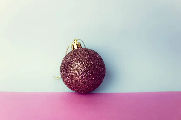 Marrón pequeño vidrio redondo plástico invierno elegante brillante decorativo hermosa Navidad festiva bola de Navidad, juguete de Navidad enyesado con lentejuelas sobre un fondo rosa púrpura azul —  Fotos de Stock