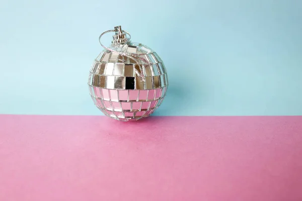 Espejo de plata club musical disco bola pequeño vidrio redondo invierno brillante decorativo hermosa fiesta de Navidad bola, juguete de Navidad enyesado en brillo sobre un fondo rosa púrpura gris —  Fotos de Stock