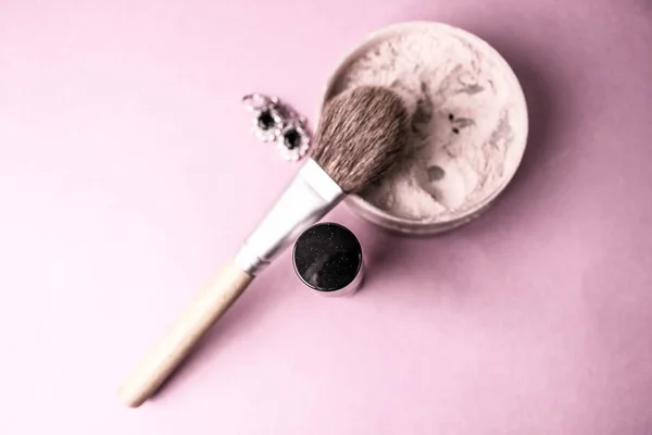 Beauty box, polvere minerale opaca friabile con una speciale spazzola di legno marrone naturale dal pisolino naturale per il trucco, profumo rosa e orecchini d'argento lucido su uno sfondo viola rosa. Piatto. Vista dall'alto — Foto Stock