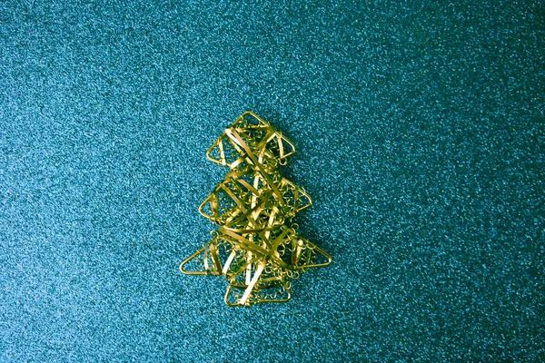 Festive New Year Christmas happy blue shiny joyful background with a small toy metal iron golden homemade Christmas tree. Flat lay. Top view. Holiday decorations — Stock Photo, Image