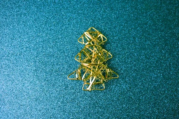 Festive New Year Christmas happy blue shiny joyful background with a small toy metal iron golden homemade Christmas tree. Flat lay. Top view. Holiday decorations — Stock Photo, Image