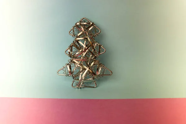 Festive Christmas Christmas happy blue-pink joyful background with a small toy metal iron golden homemade Christmas tree. Holiday decorations — Stock Photo, Image