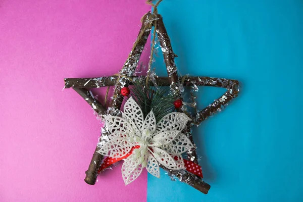 Grande decorativa hermosa estrella de Navidad de madera, una corona de adviento hecho a sí mismo de ramas de abeto y palos en el festivo año nuevo feliz fondo alegre azul-rosa. Decoraciones navideñas — Foto de Stock