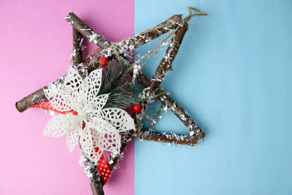 Grande decorativa hermosa estrella de Navidad de madera, una corona de adviento hecho a sí mismo de ramas de abeto y palos en el festivo año nuevo feliz fondo alegre azul-rosa. Decoraciones navideñas — Foto de Stock