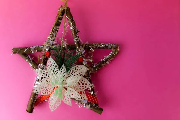 Large decorative beautiful wooden Christmas star, a self-made advent wreath of fir branches and sticks on the festive New Year happy pink purple joyful background. Holiday decorations — Stock Photo, Image