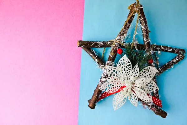 Grande decorativa hermosa estrella de Navidad de madera, una corona de adviento hecho a sí mismo de ramas de abeto y palos en el festivo año nuevo feliz fondo alegre azul-rosa. Decoraciones navideñas — Foto de Stock