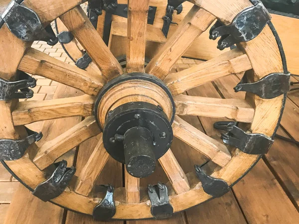 Большое старинное колесо из повозки, повозки, повозки, деревянного средневекового круга с железными коваными частями. Фон — стоковое фото