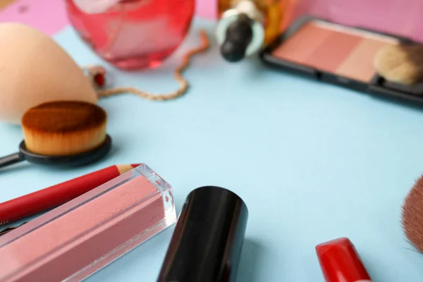 Bildruta från en uppsättning av kvinnliga kosmetika från ett läppstift, highlighter, en penna för läppar, borstar, penslar, parfym, puder, ornament på en blå bakgrund. Beauty box platt låg. Ovanifrån — Stockfoto