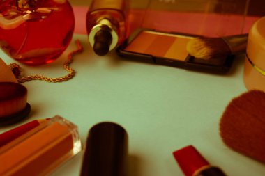 Çerçeve bir ruj, vurgulayıcı, dudaklar, fırça, fırçalar, parfüm, pudra, için bir kalem kadın kozmetik bir dizi mavi bir arka plan üzerinde süsler. Güzellik kutusunu düz yatıyordu. Üstten görünüm