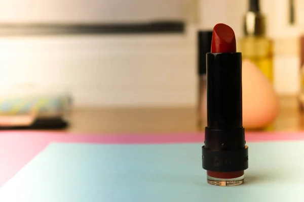 Rojo lipad de moda de los labios, y resaltador en el fondo de una mesa de maquillaje de belleza —  Fotos de Stock