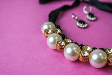 Güzel pahalı değerli parlak mücevher moda göz alıcı takı, kolye ve küpe inciler ve elmas, elmas pembe mor arka plan ile. Düz yatıyordu, en iyi görünüm, kopya yer