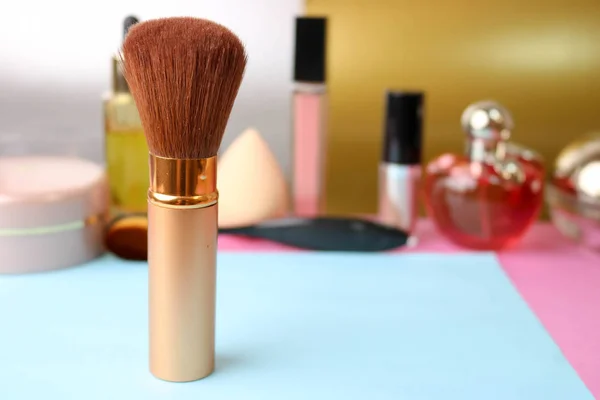 Gentle brush of natural lint for applying powder on the background of a cosmetic table for makeup for beauty guidance