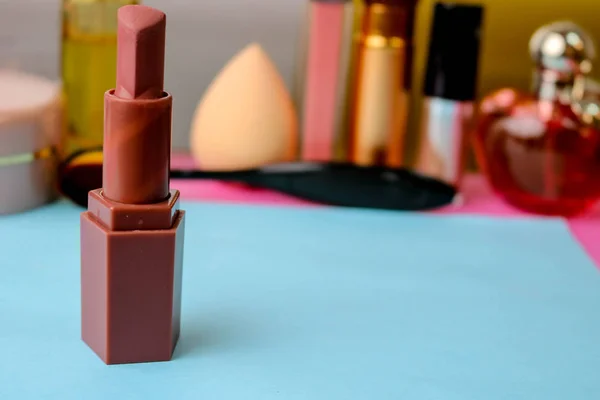 Rosa de moda lápiz labial glamoroso, y resaltador contra el fondo de una mesa cosmética para el maquillaje para la guía de belleza — Foto de Stock