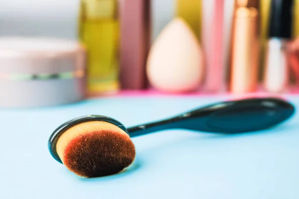 Wooden brush made of natural lint for applying tone on the background of a cosmetic table for makeup for beauty guidance