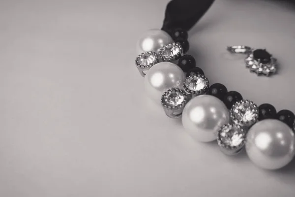 Belas jóias brilhantes preciosas caras jóias glamourosas na moda, colar e brincos com pérolas e diamantes, diamantes em um fundo preto e branco. Colocação lisa, vista superior, lugar da cópia — Fotografia de Stock