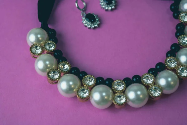 Schönen kostbaren glänzenden Schmuck modischen glamourösen Schmuck, Halskette und Ohrringe mit Perlen und Diamanten, Diamanten auf rosa lila Hintergrund. flache Lage, Draufsicht, Kopierplatz — Stockfoto