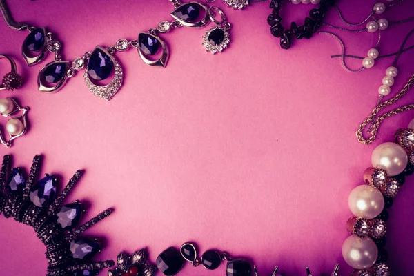 Beaux bijoux brillants précieux bijoux glamour tendance serti, collier, boucles d'oreilles, bagues, chaînes, broches avec des perles et des diamants sur un fond violet rose. Pose plate, vue du dessus, endroit de copie — Photo